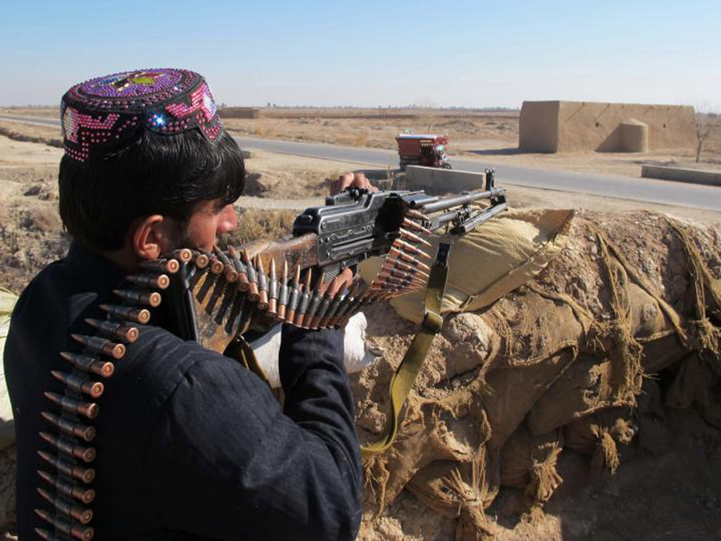 Cảnh sát vũ trang Afghanistan xả súng về phía quân Taliban trong cuộc giao chiến ở tỉnh Helmand ngày 23.12.2015 - Ảnh: Reuters