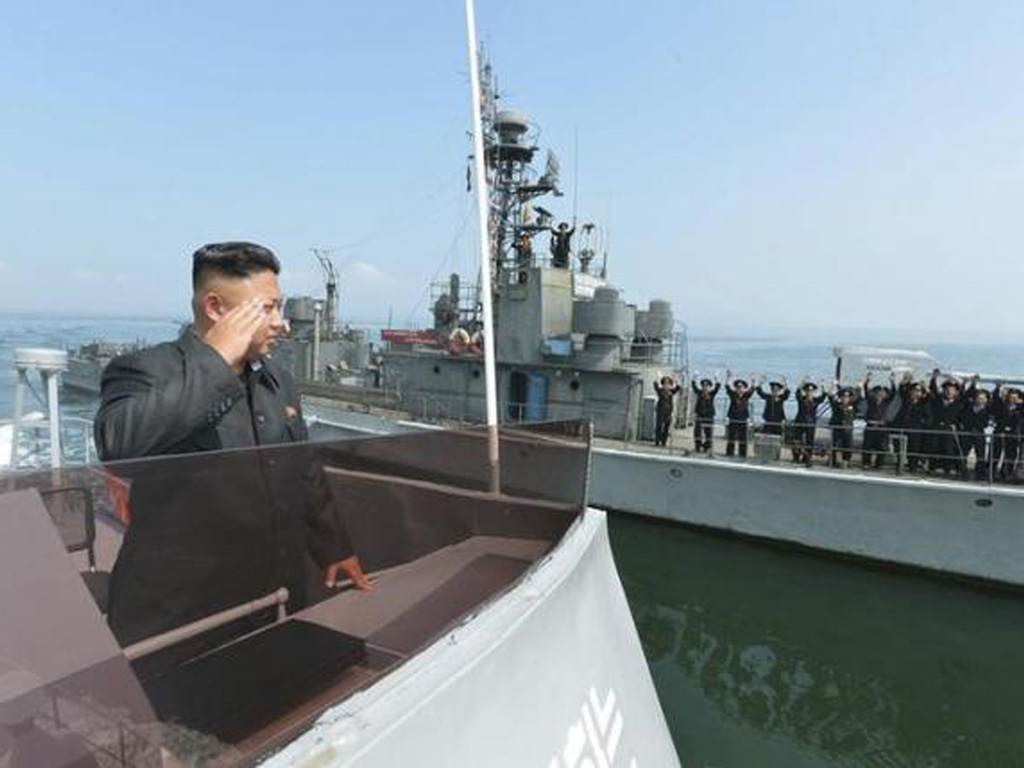 Lãnh đạo Kim Jong Un (trái) duyệt đội hình các lực lượng vũ trang Triều Tiên, trong ảnh là 1 tàu chiến của nước này, hồi năm 2014. Hội đồng bảo an LHQ cho rằng ít nhất 3 tàu chiến Triều Tiên trang bị radar do Nhật sản xuất - Ảnh: KCNA/Reuters