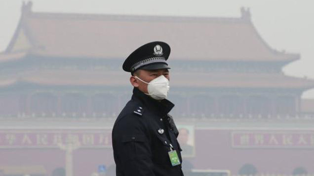 Nhân viên an ninh trước quảng trường Thiên An Môn (Bắc Kinh) ngày 3.3, nơi diễn ra kỳ họp của Quốc hội Trung Quốc, phải đeo khẩu trang do ô nhiễm không khí trầm trọng - Ảnh: Reuters