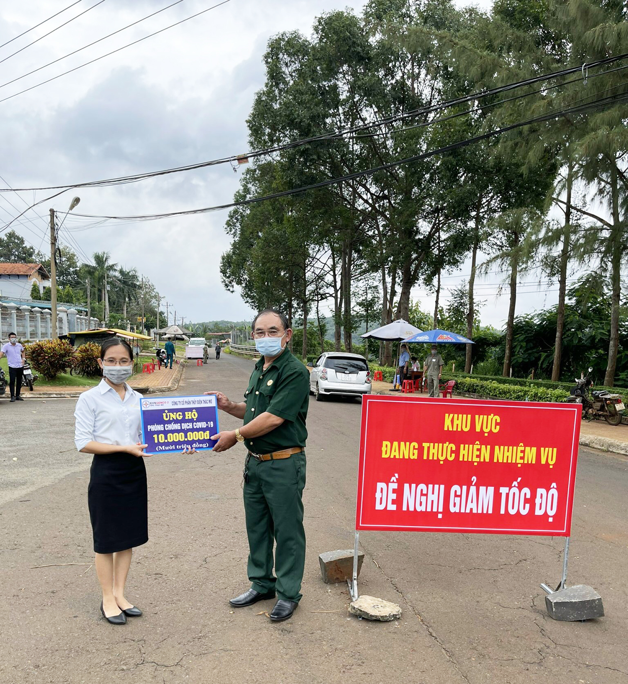 Bà Hồ Nguyễn Phương Trâm, Trưởng phòng Hành chính và Lao động trao tiền ủng hộ tại chốt kiểm soát dịch P.Long Thủy, TX.Phước Long