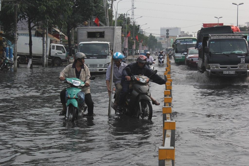 Đoạn ngập kéo dài khoảng 200 m trên đường Kinh Dương Vương (phường An Lạc, quận BÌnh Tân) gây khó khăn cho người đi đường - Ảnh: Phạm Hữu 