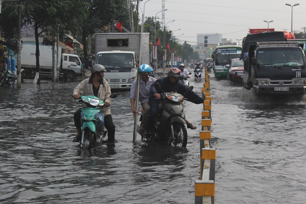 Đoạn ngập kéo dài khoảng 200 m trên đường Kinh Dương Vương (phường An Lạc, quận BÌnh Tân) gây khó khăn cho người đi đường - Ảnh: Phạm Hữu