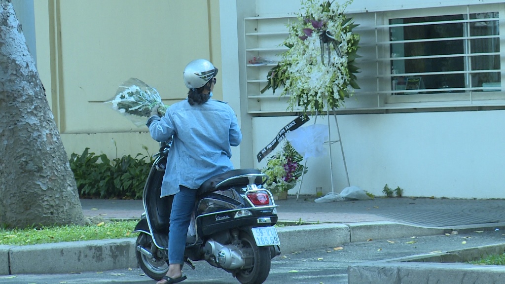 Một người dân đi xe gắn máy dừng lại trước cổng Tổng lãnh sự quán Pháp tại TP.HCM để gửi lại bó hoa chia buồn với những nạn nhân bị khủng bố ở Paris