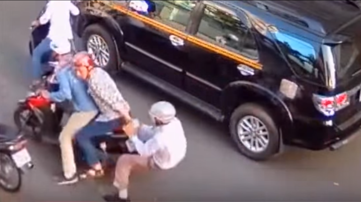 Hai tên cướp kéo lê anh Hải nhằm cướp cho bằng được tiền  - Ảnh cắt từ video clip