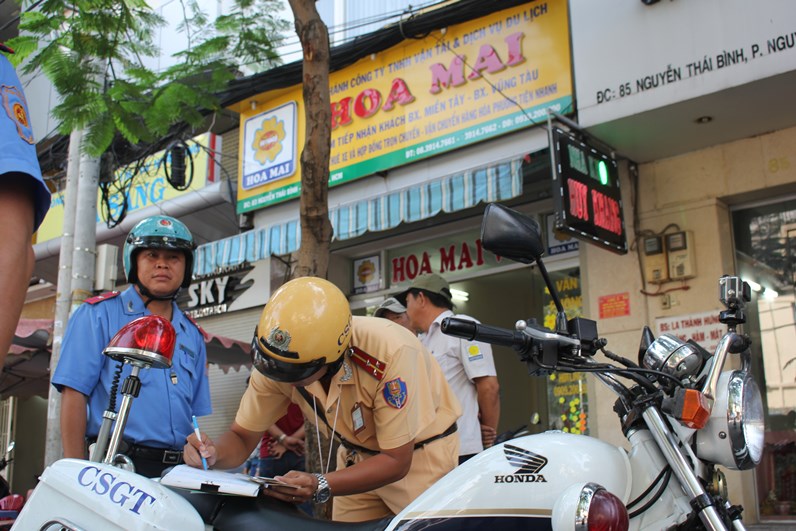 Lực lượng TTGT cùng CSGT xử lý xe vi phạm trên đường Nguyễn Thái Bình - Ảnh: Phạm Hữu