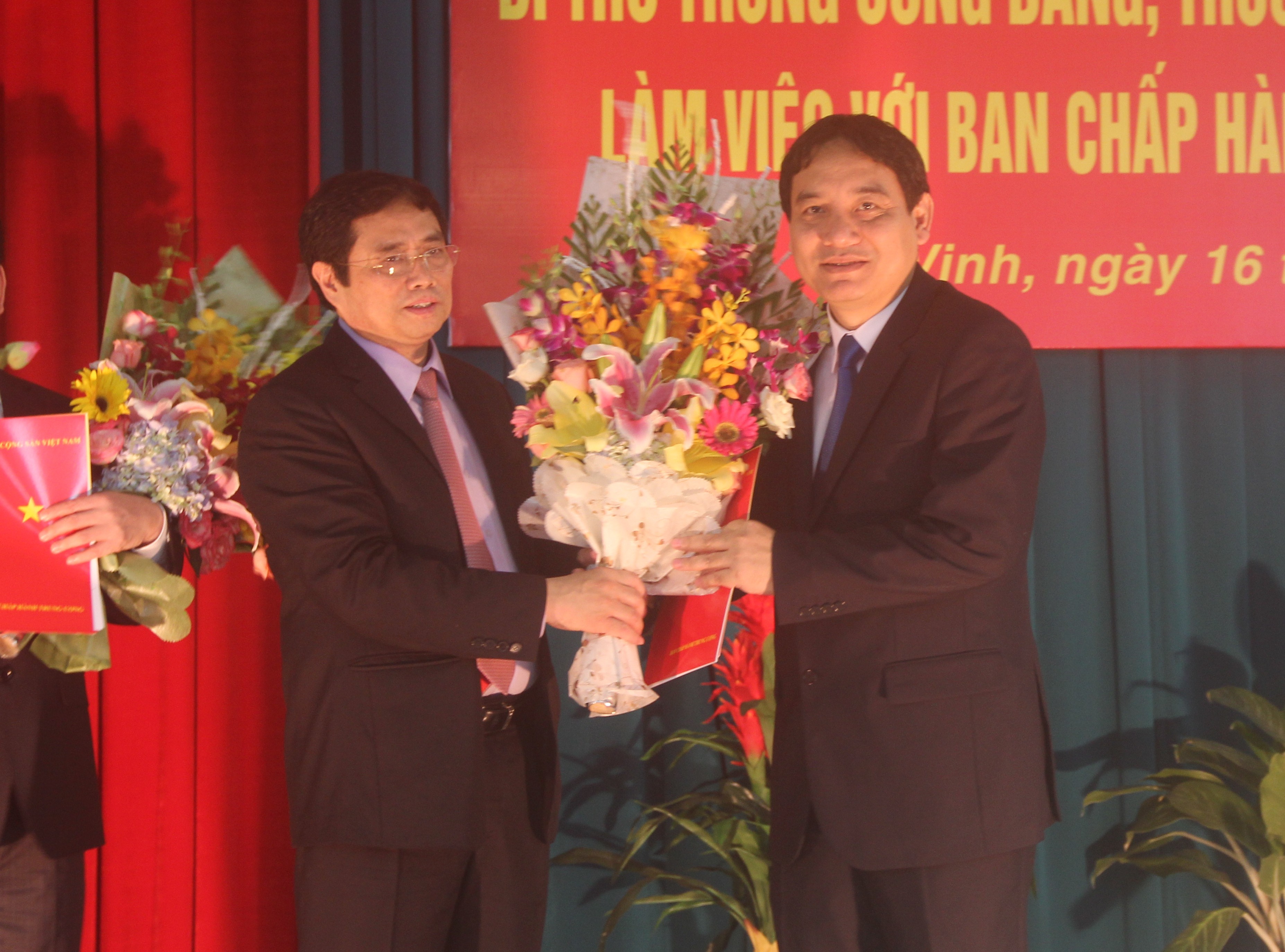 Ông Phạm Minh Chính (trái) trao quyết định của Bộ Chính trị và tặng hoa tân Bí thư Tỉnh ủy Nghệ An