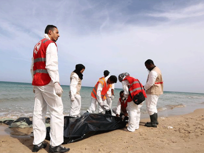 Nhân viên Hội Trăng lưỡi liềm đỏ ở Syria xử lý các xác người trôi dạt vào bờ biển - Ảnh: AFP