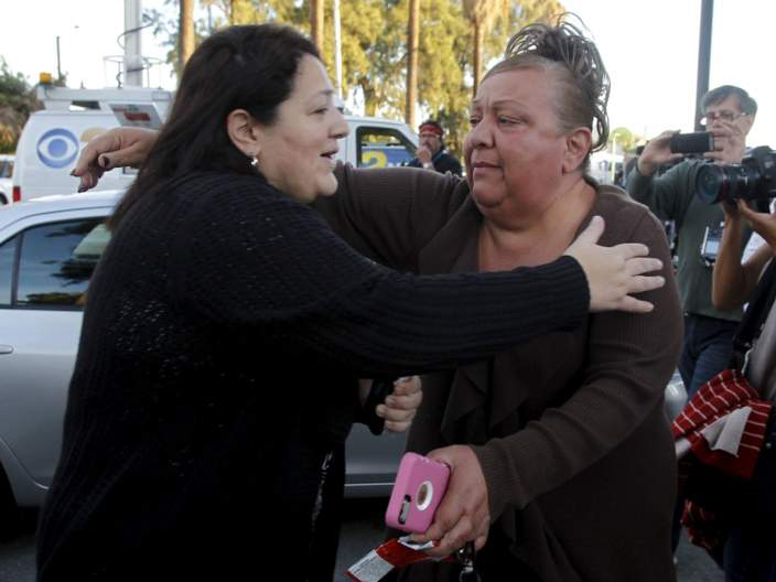 Một người làm việc trong tòa nhà xảy ra vụ xả súng ở  San Bernardino, California (Mỹ) đoàn tụ với người thân - Ảnh: Reuters