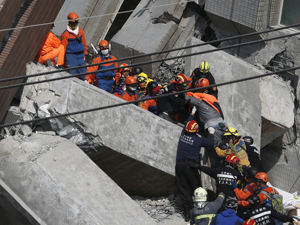 Lực lượng cứu hộ đang làm việc hết tốc lực để cố cứu 100 người còn kẹt dưới đống đổ nát - Ảnh: Reuters