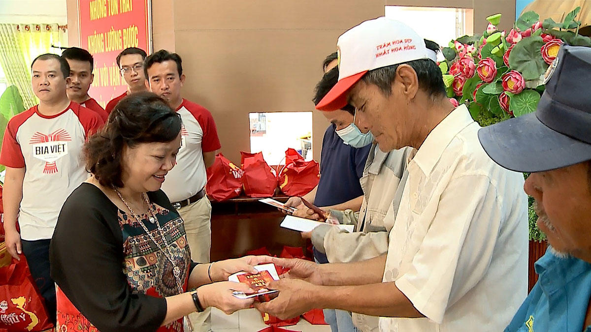 Chị Phạm Thị Mỹ Trang, Phó Giám đốc Công ty TNHH XNK Minh Quang, trao quà cho bà con tại huyện Hóc Môn, TP.HCM