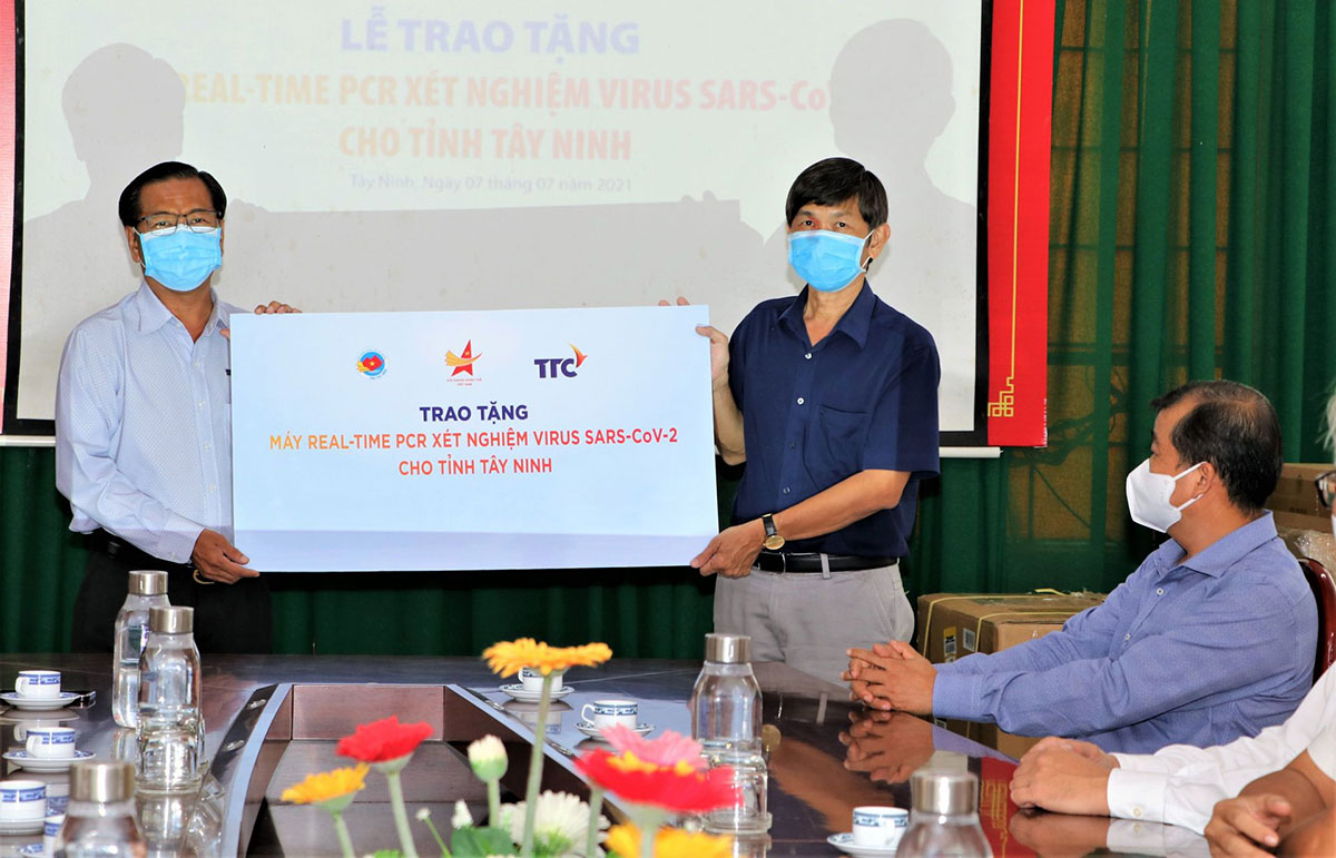 Đại diện Công ty CP KCN Thành Thành Công (áo xanh nhạt) trao biểu trưng tặng máy xét nghiệm cho Sở Y tế Tây Ninh