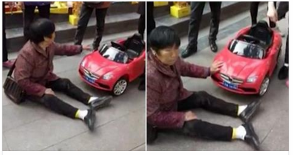 Người phụ nữ ngồi ăn vạ dưới lòng đường sau khi chiếc ô tô đồ chơi đâm vào chân - Ảnh chụp màn hình fanpage Facebook Daily Mail
