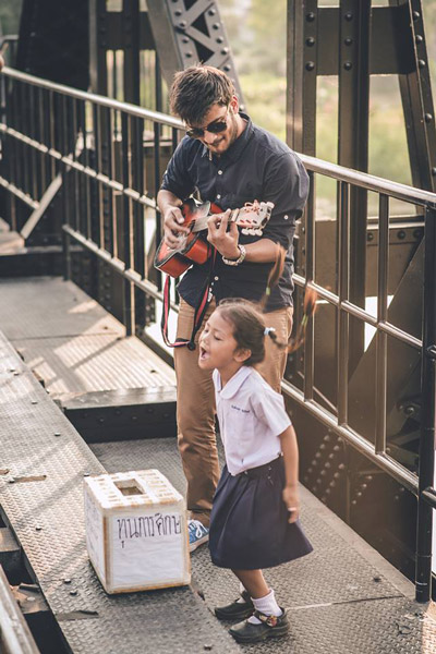Cô bé say sưa hát bên tiếng đàn của du khách nước ngoài dưới ống kính của Mai Hirunwat - Ảnh do Mai Hirunwat cung cấp