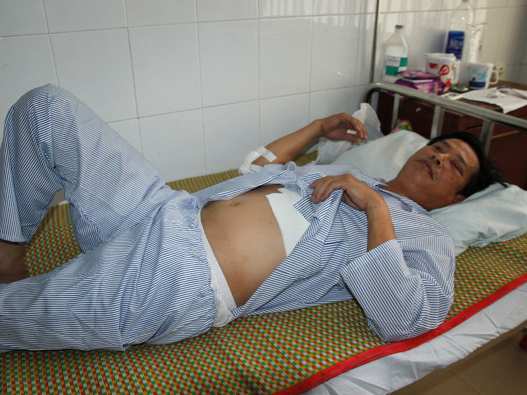Ông Trịnh Anh Tú bị nhóm người bán hàng rong trước bệnh viện đánh trọng thương - Ảnh: Hoàng Sơn