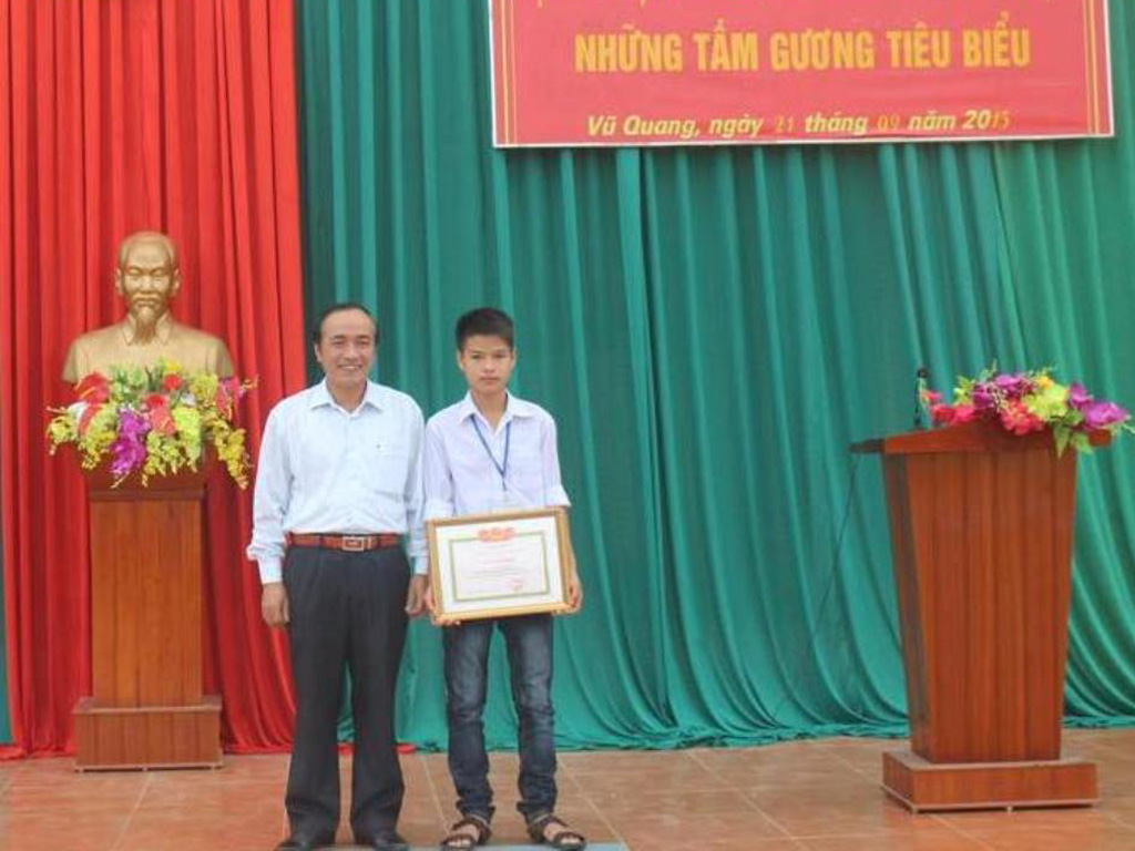 Ông Trần Trung Dũng, Giám đốc Sở Giáo dục và Đào tạo Hà Tĩnh tặng Bằng khen cho em Nguyễn Hữu Thắng - Ảnh: Châu Dũng