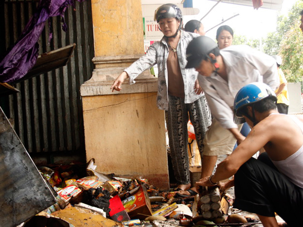 Tiểu thương chợ Tứ Hạ lục tìm tài sản còn sót lại trong đống tro tàn sau vụ cháy - Ảnh: Đình Toàn