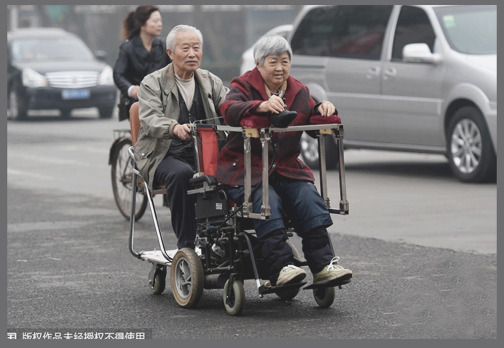 Ông Xu Suobao và bà Zhoushu Di trên chiếc xe lăn cải tiến - Ảnh chụp màn hình tờ China Daily