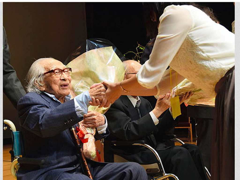 Ông Muno được tặng hoa chúc mừng tại lễ nhận bằng vừa qua - Ảnh chụp từ Asahi Shimbun