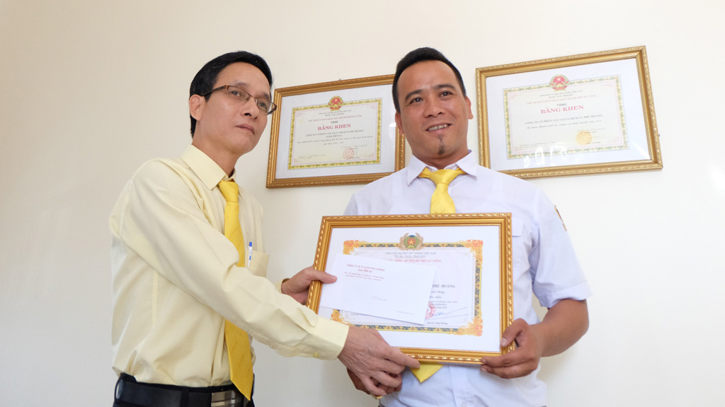 Ông Nguyễn Văn Hiền (trái) khen thưởng tài xế Võ Chí Công - Ảnh: Hữu Trà