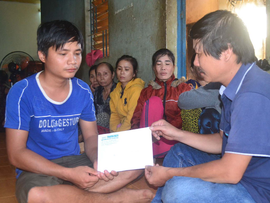 Đại diện Báo Thanh Niên trao tiền hỗ trợ cho gia đình ông Bảy - Ảnh: CTV