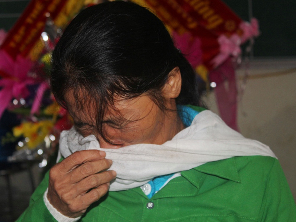 Bà Kim òa khóc sau khi nhận Huân chương Dũng cảm của Chủ tịch nước thay cho con - Ảnh: Phạm Đức