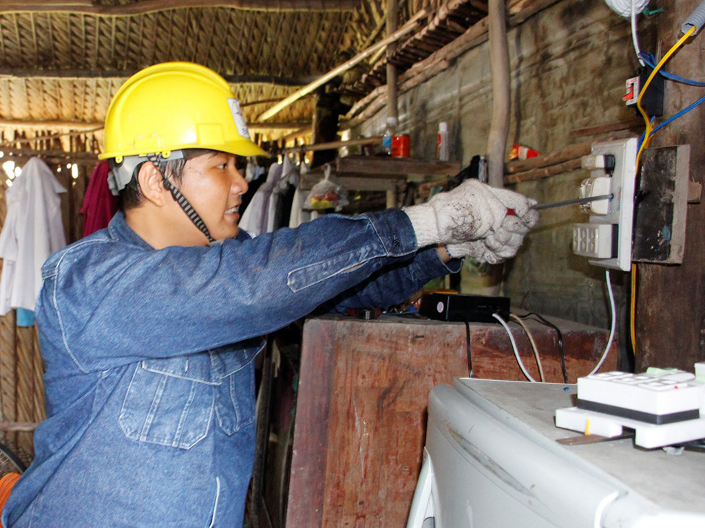 Các thợ điện trẻ Đoàn Tổng công ty điện lực TPHCM tiến hành sửa điện cho các hộ nghèo tại xã Long Thới, H.Nhà Bè - Ảnh: Lê Thanh