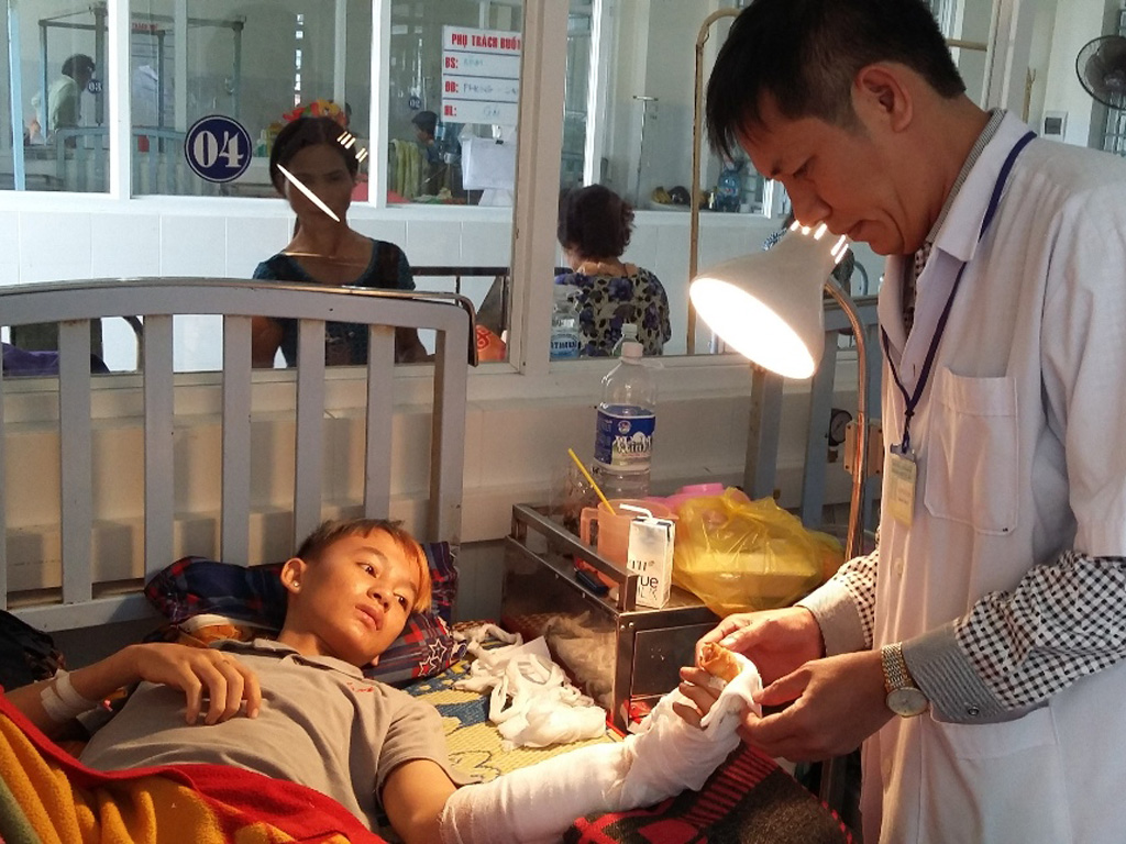 Thạc sĩ Thái Thanh Bình kiểm tra bàn tay của bệnh nhân Duy - Ảnh: Tâm Ngọc