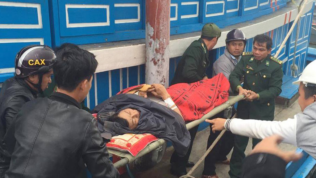 Đưa bệnh nhân Nguyễn Văn Tiến lên tàu cá của ngư dân để vào bờ cấp cứu - Ảnh: Hồng Anh