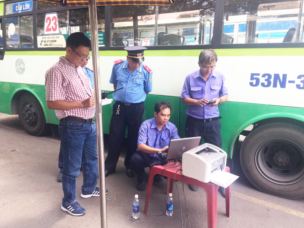 Dùng thiết bị kiểm tra khí thải xe buýt tại Bến xe Chợ Lớn - Ảnh: Đình Mười