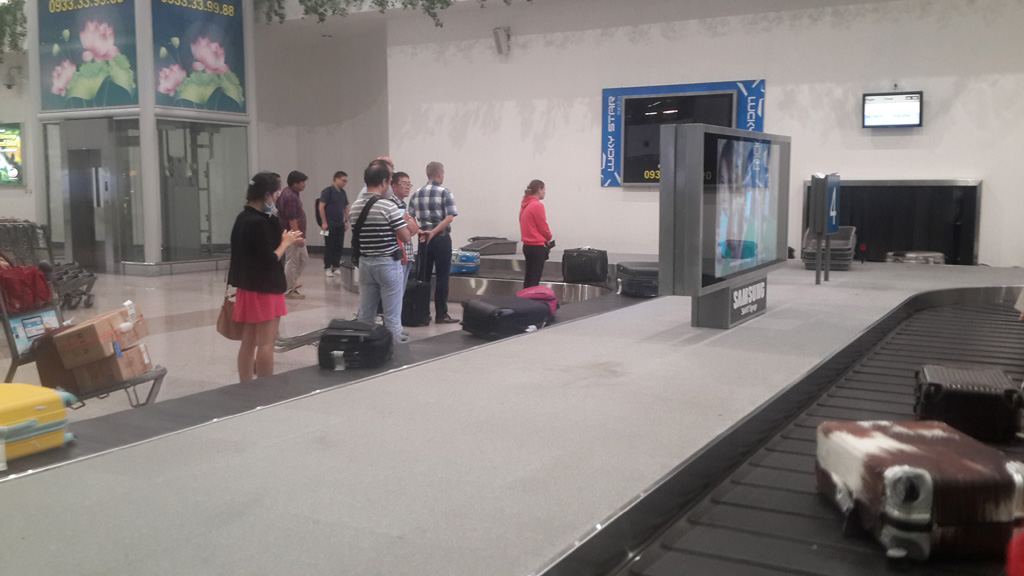 Hành khách chờ lấy hành lý ở băng chuyền trong Sân bay quốc tế Tân Sơn Nhất - Ảnh: H.S