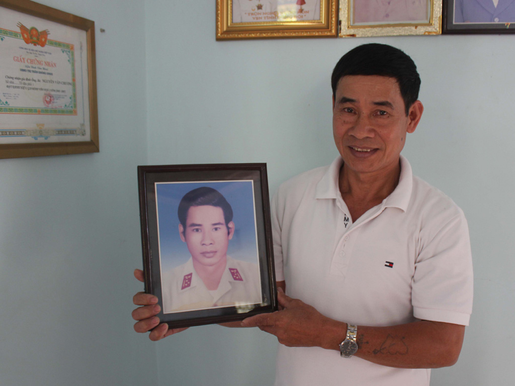 Người cựu binh Trường Sa với bức ảnh thời còn quân ngũ - Ảnh: Ngọc Quyền