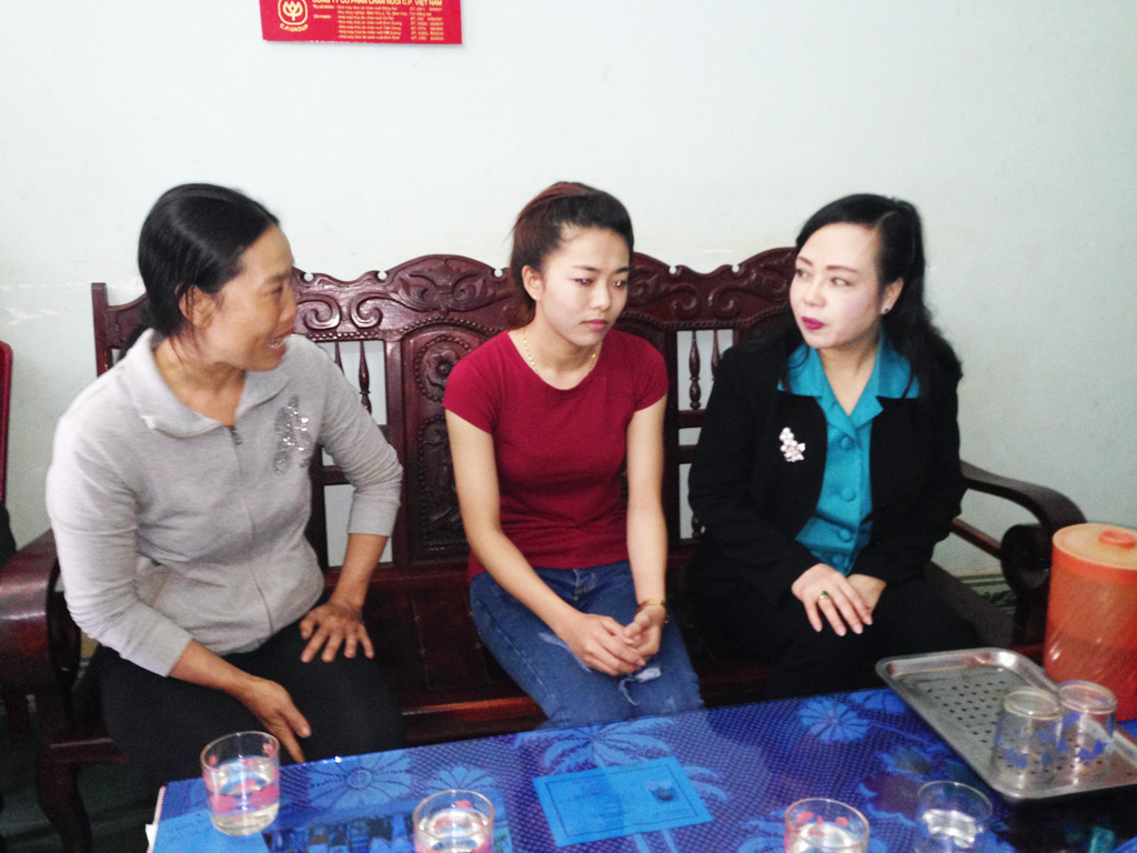 Bộ trưởng Nguyễn Thị Kim Tiến (ngoài cùng bên phải) thăm hỏi gia đình em Vi - Ảnh: Ngọc Anh