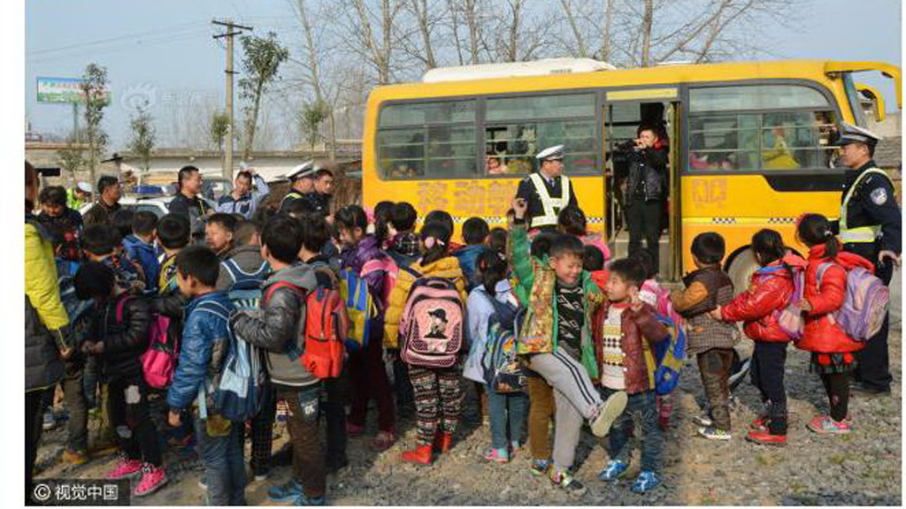 Các em học sinh được hộ tống về nhà sau khi chen chúc nhau trên xe buýt quá tải - Ảnh chụp màn hình Shanghaiist