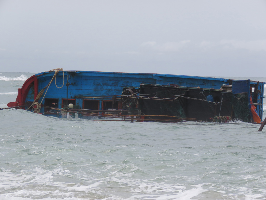 Tàu cá PY-90441 bị sóng đánh lật nghiêng, chìm nửa tàu và phần ca bin bị hỏng hoàn toàn - Ảnh: Đức Huy 