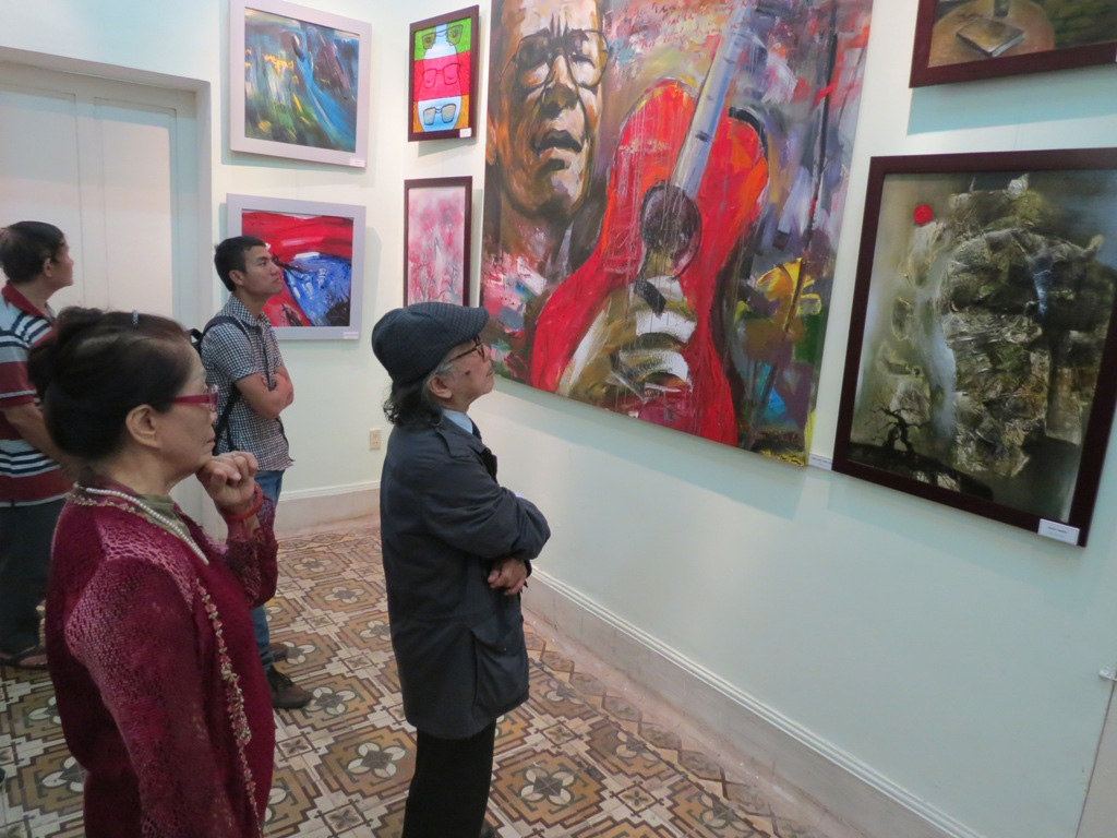 Nhà văn, dịch giả Bửu Ý một người bạn thân của Trịnh Công Sơn cùng khán giả xem tranh