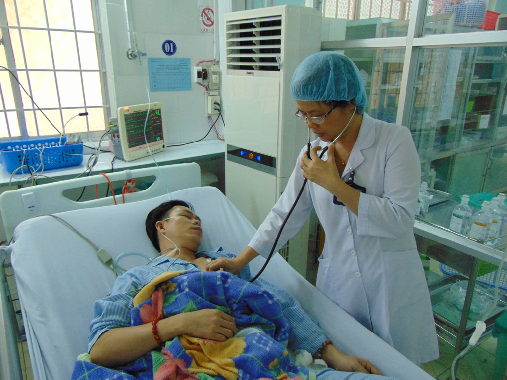 Bác sĩ Nga đang chăm sóc sức khỏe cho anh Minh - Ảnh: Nguyễn Long