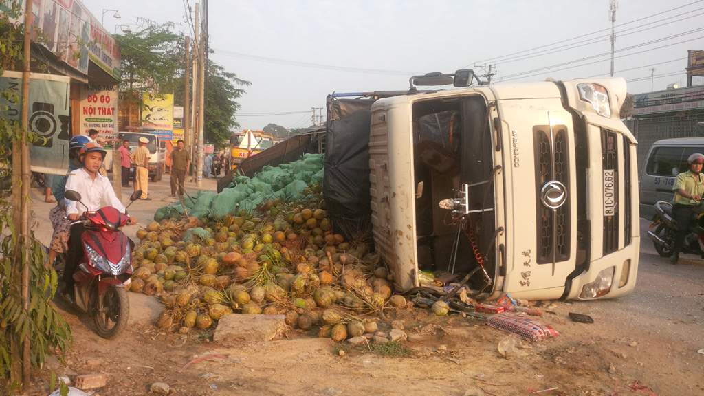 Xe bị lật khiến hàng trăm trái dừa rơi xuống đường - Ảnh: Lê Lâm