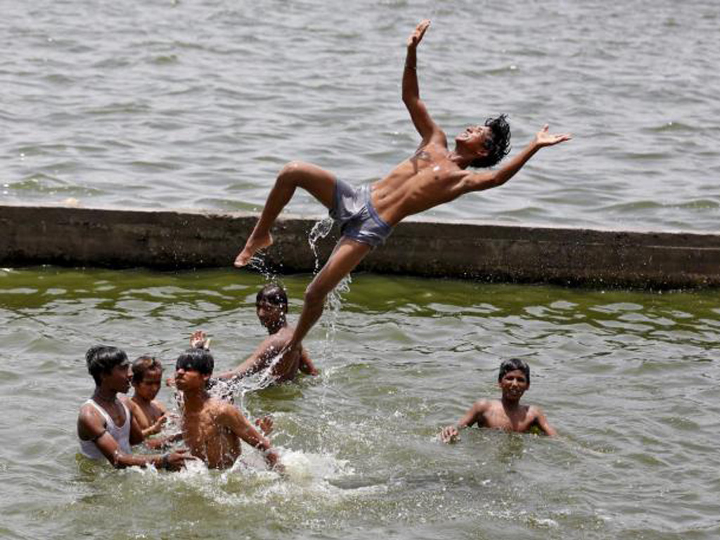 Nắng nóng, nhiều thanh thiếu niên Ấn Độ phải tắm sông - Ảnh: Reuters
