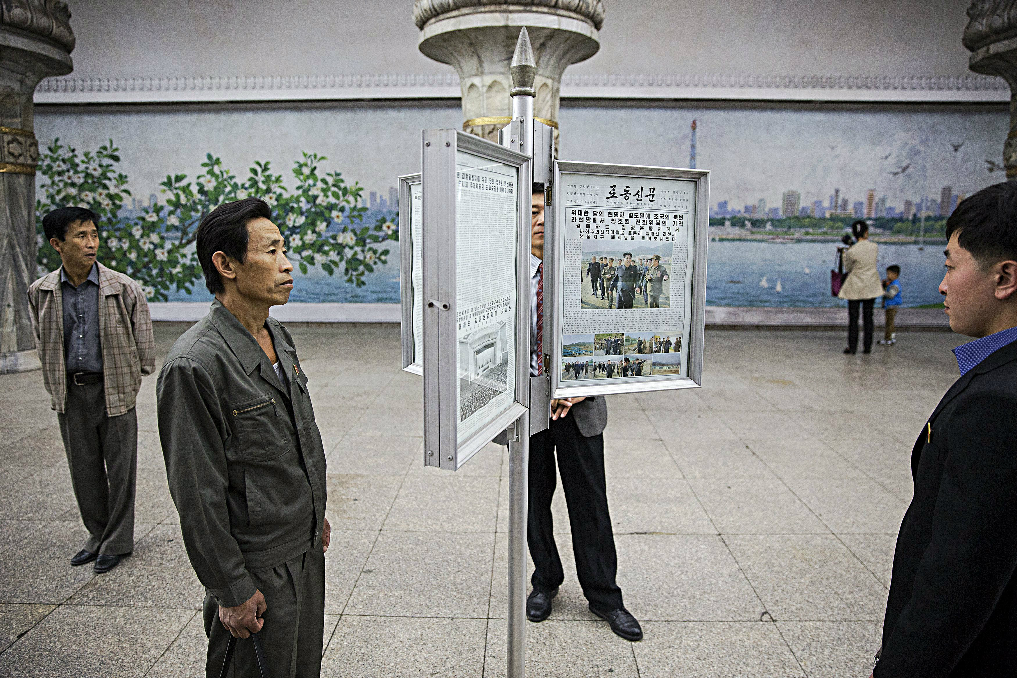 Người dân Triều Tiên đọc tin tức trên bảng tin công cộng - Ảnh: Reuters