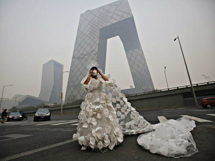 Một cô dâu Trung Quốc chuẩn bị khẩu trang để chụp ảnh ngoại cảnh - Ảnh: Reuters