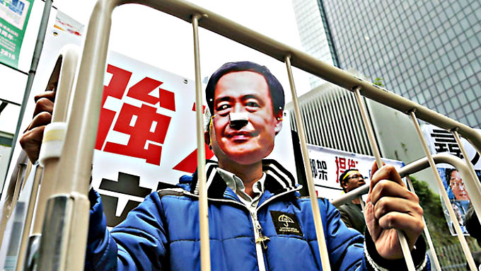 Một người ủng hộ mang mặt nạ Lee Bo phản đối việc giam giữ ông này - Ảnh: AFP
