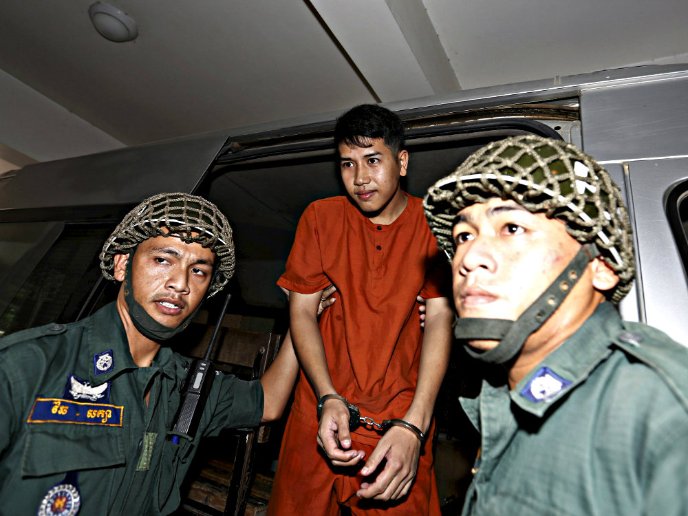 Sinh viên Kong Raya bị áp tải khỏi toà án ở Phnom Penh ngày 15.3 với mức án 18 tháng tù vì chỉ trích chính phủ Campuchia trên tài khoản Facebook cá nhân - Ảnh: Reuters