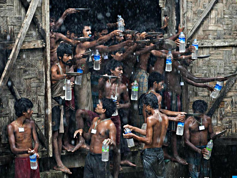 Người Rohingya ở bang Rakhine, Myanmar đang hứng nước mưa để uống - Ảnh: AFP