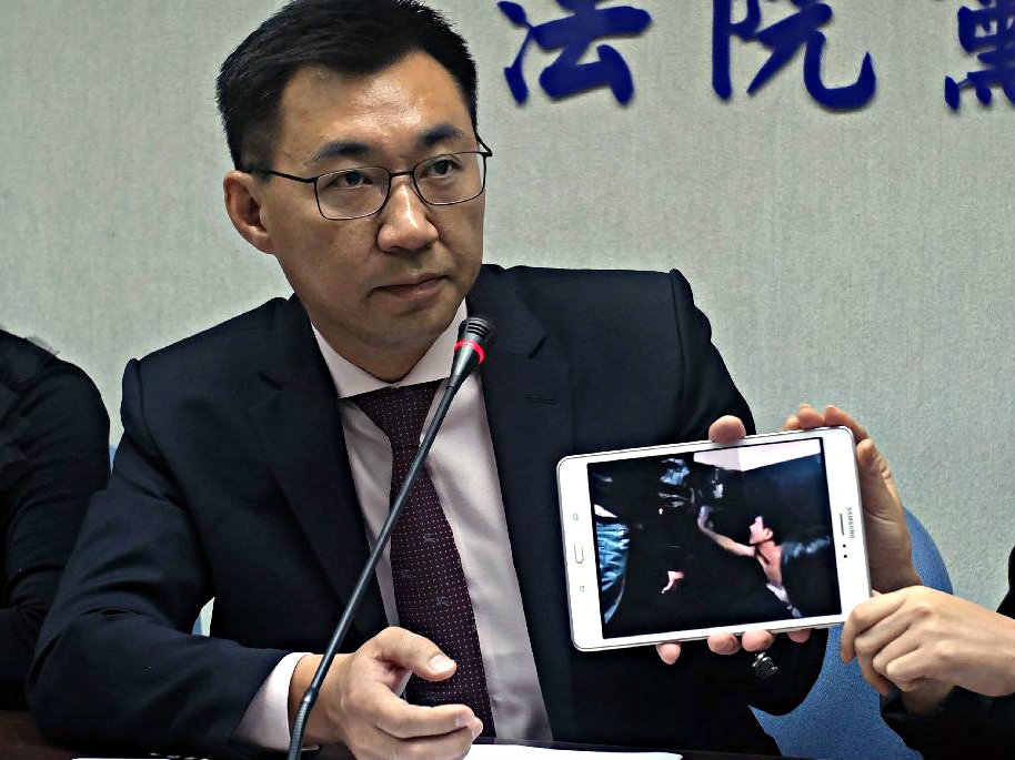 Ông Johnny Chiang, người của Quốc dân đảng đang cầm quyền, cho báo chí xem hình ảnh những người Đài Loan bị ép về Trung Quốc - Ảnh: AFP