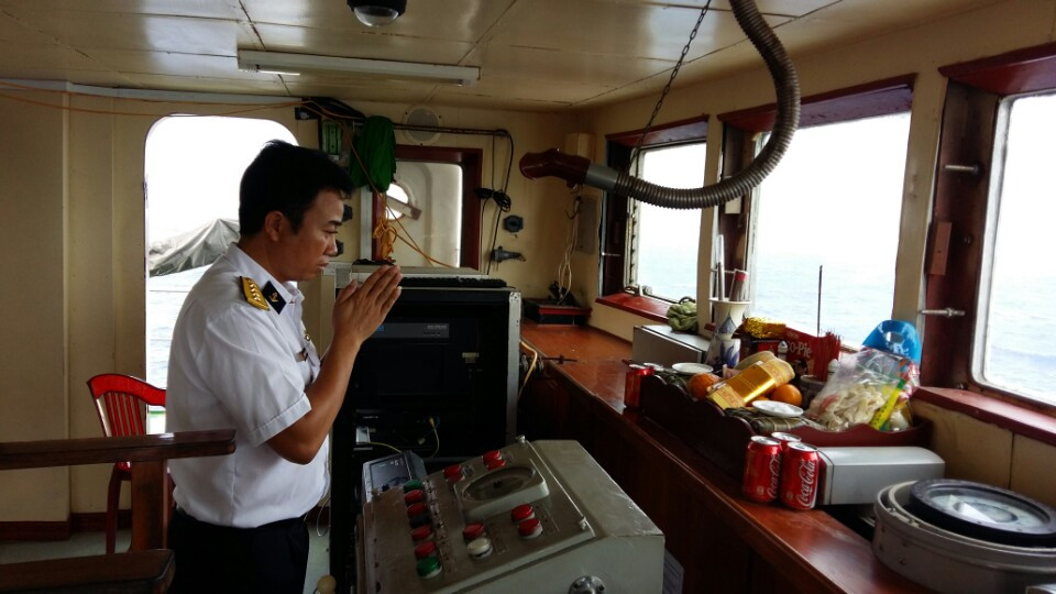 Đại úy Nguyễn Xuân Thắng, thuyền trưởng tàu Trường Sa 22 thắp hương bàn thờ Tết, trên buồng lái - Ảnh: Mai Thanh Hải