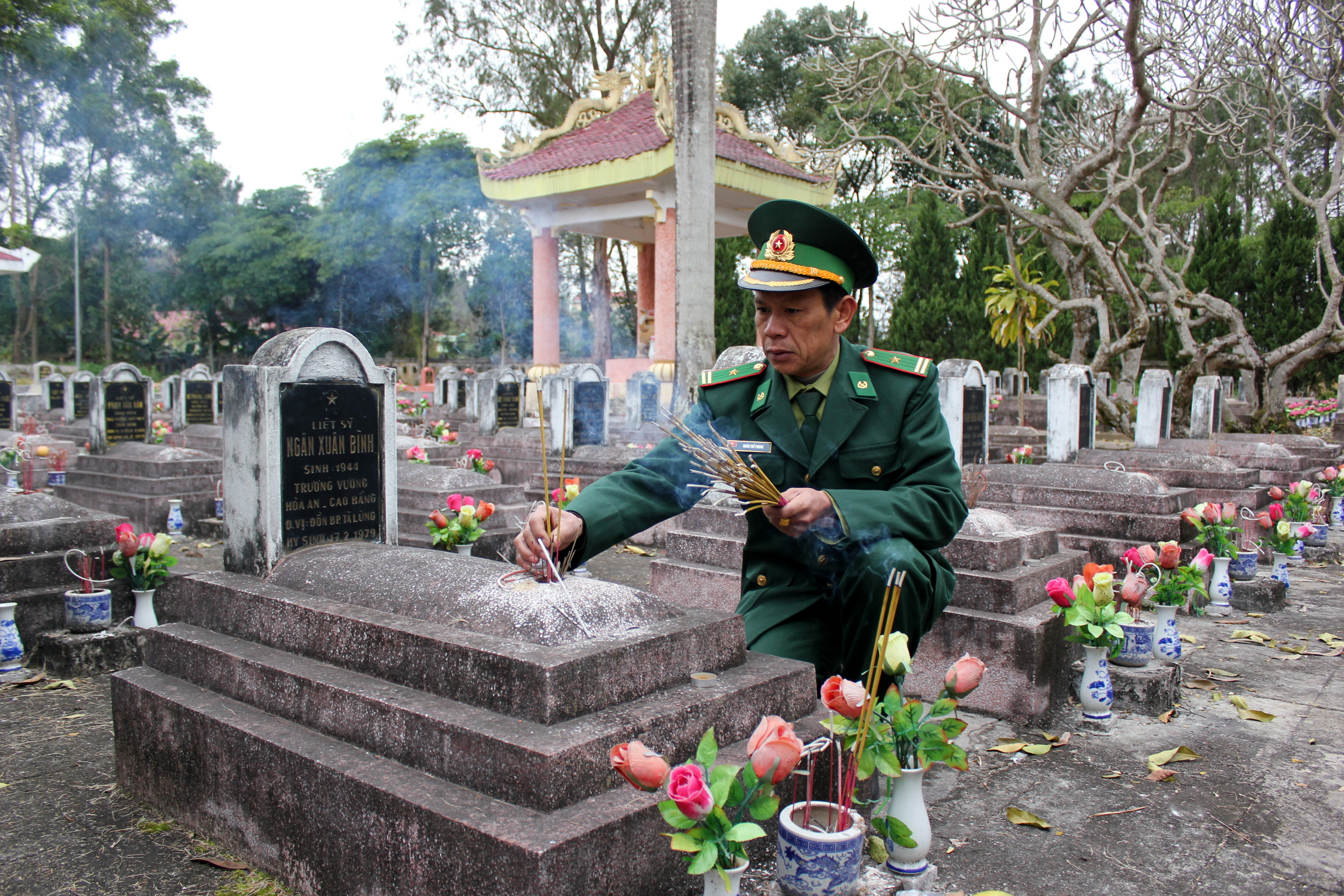Thiếu tá Ngân Thế Phong thắp hương cho bố là liệt sĩ Ngân Xuân Bình, đang nằm tại Nghĩa trang liệt sĩ tỉnh Cao Bằng, sáng 17.2.2016 - Ảnh: Hà Quỳnh Trang