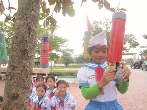 Học sinh trường Trường tiểu học Tân Lộc thích thú “hái” sách báo trên cây để đọc 