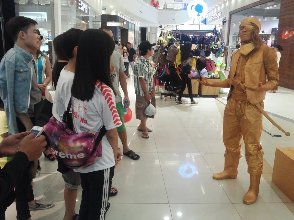 Phạm Tuấn Vỹ khiến nhiều khách hàng tại một trung tâm thương mại thích thú khi hóa thân thành bức tượng một thuyền trưởng - Ảnh: T.Đ