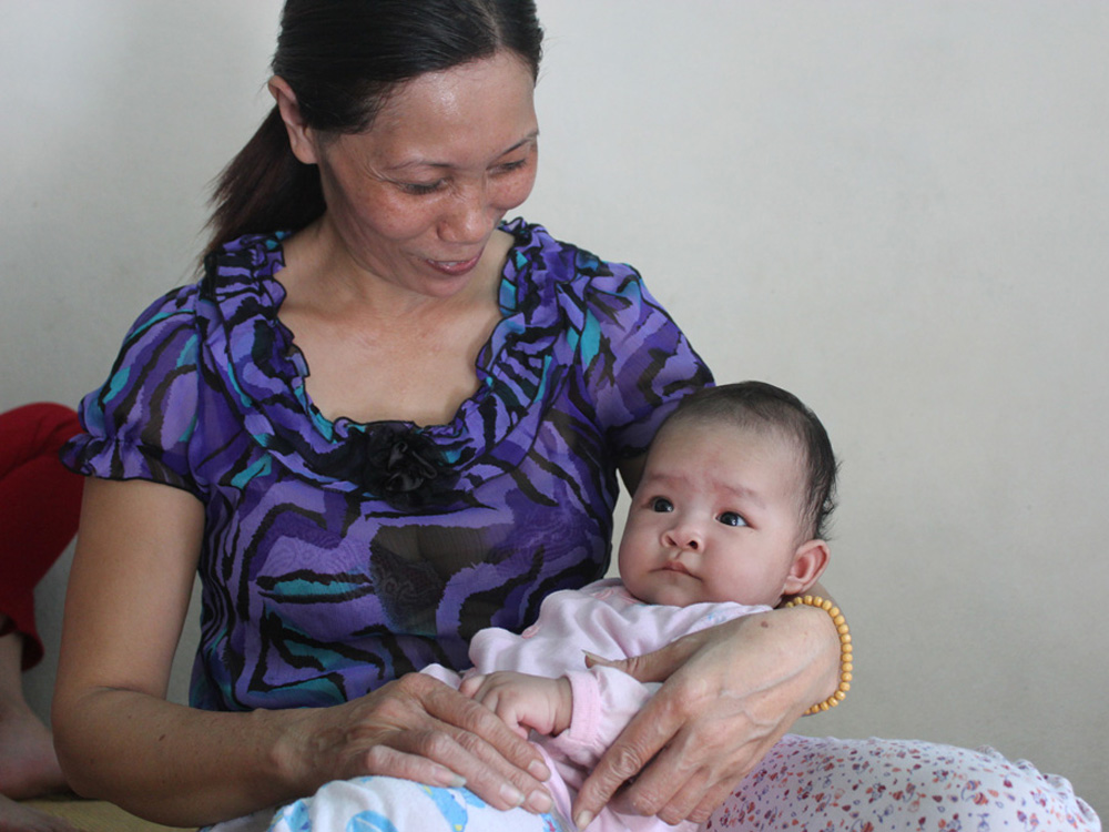 Em bé trong vòng tay bà Mai - Ảnh: Lê Tân