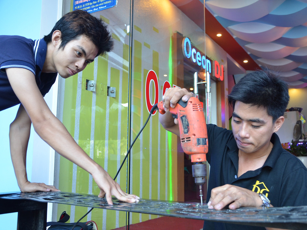 Nguyễn Trùng Dương (phải) đang trang trí cho một quán karaoke ở TP.Quy Nhơn - Ảnh: Tâm Ngọc